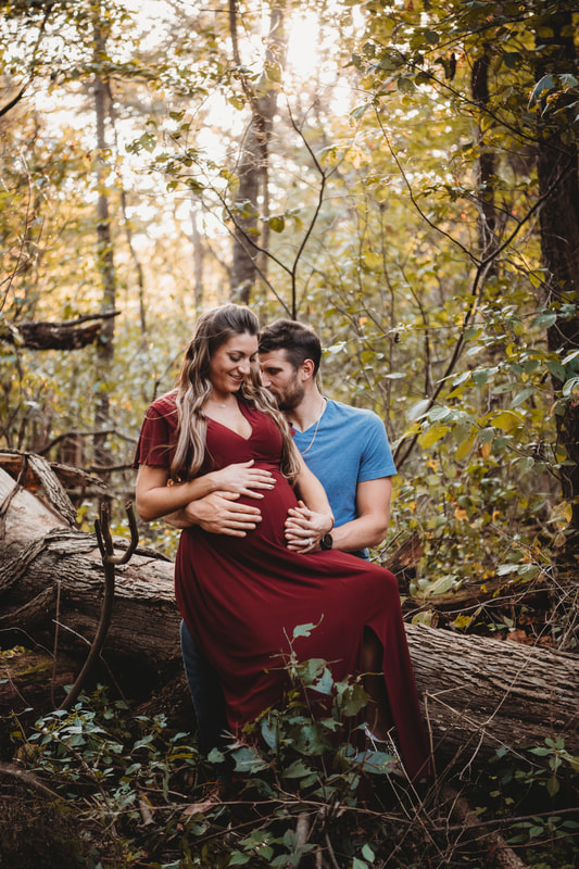 Maternity session couple sitting on a log in townsend park