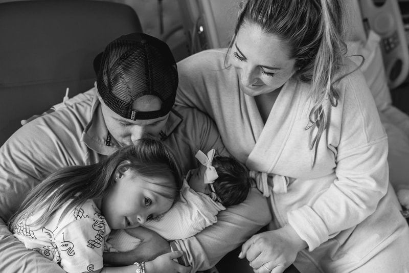 Family snuggling their new baby girl at Pittsburgh hospital Fresh 48 session