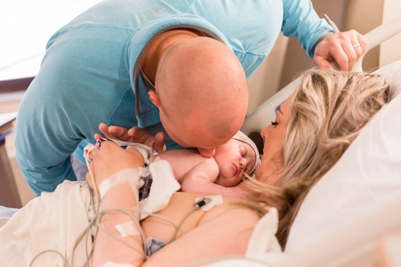 Dad kissing baby on mom's chest after c-section at pittsburgh hospital