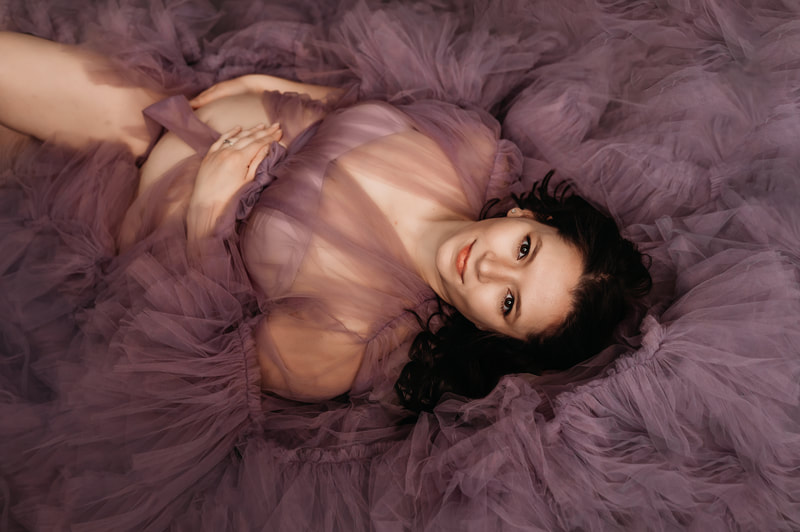 Laying down fine art maternity photo on purple robe