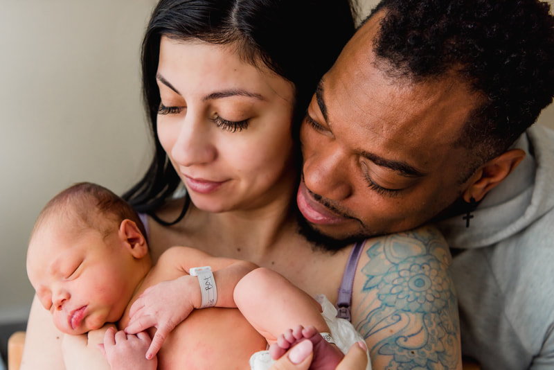 Mom and dad snuggle new baby in the hospital