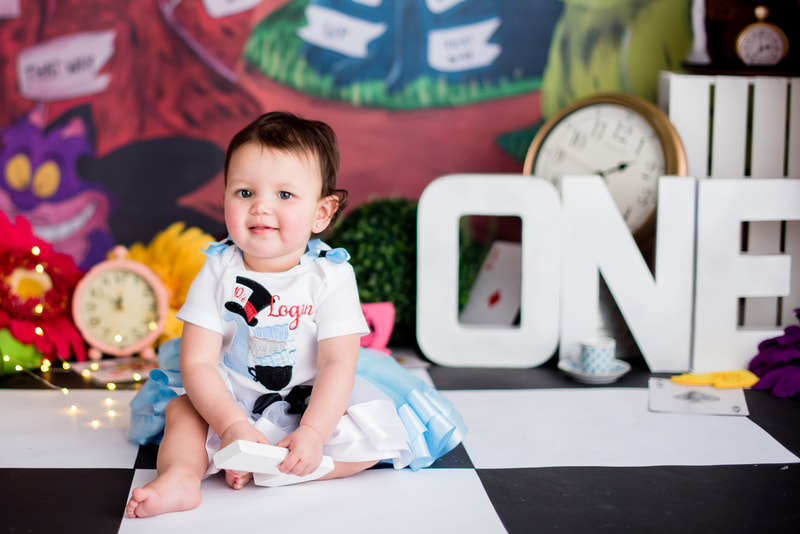Baby in Alice in Wonderland dress for first birthday session