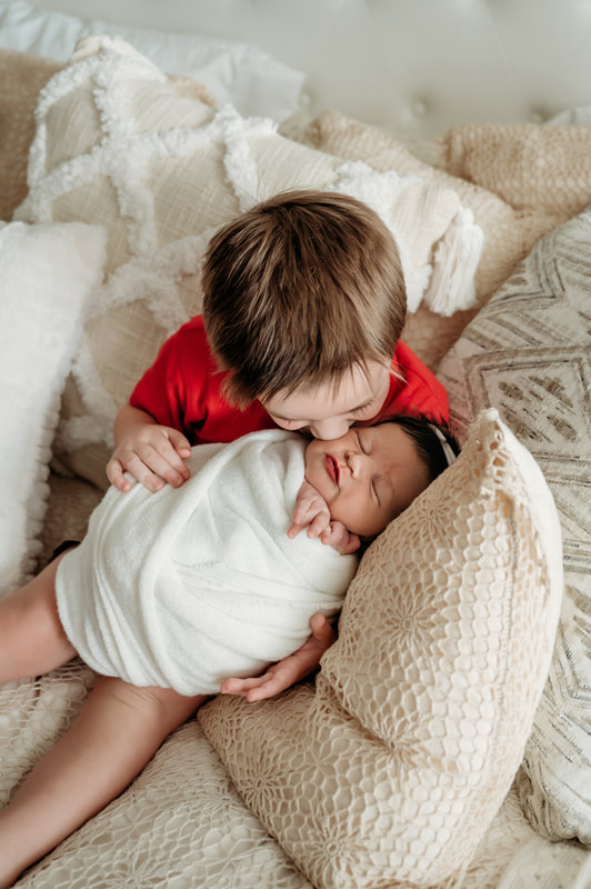 Big brother kissing his newborn sister at Murrysville Photography studio