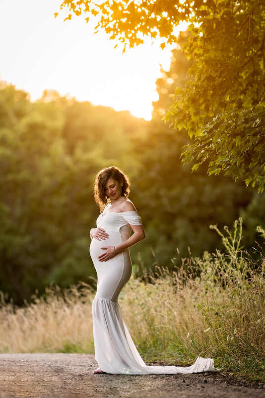 Pregnant woman in white dress in sunset maternity session at North Park