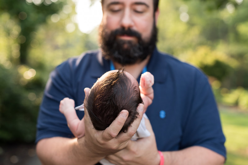 Dad holding baby with hair outside for newborn session